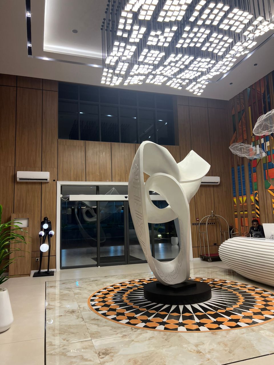Hotel corridor with layered ceiling lighting and patterned carpet runner