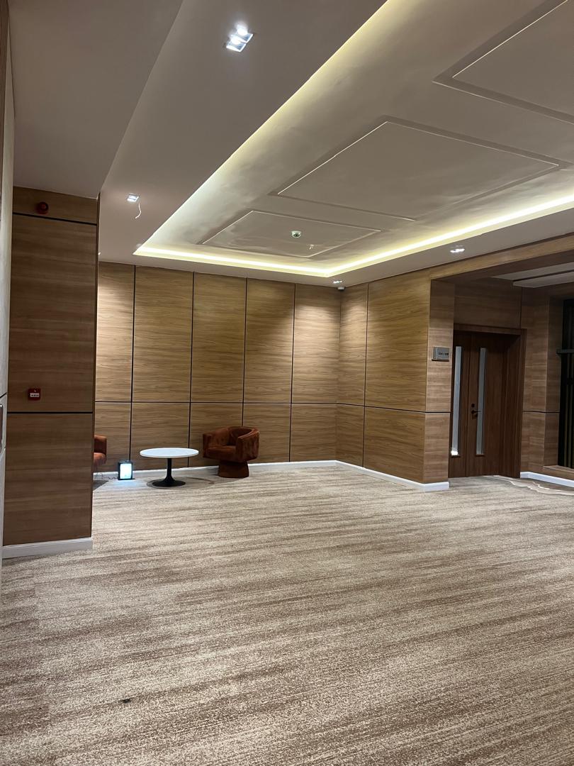 Blue lounge interior with patterned flooring and mural ceiling artwork