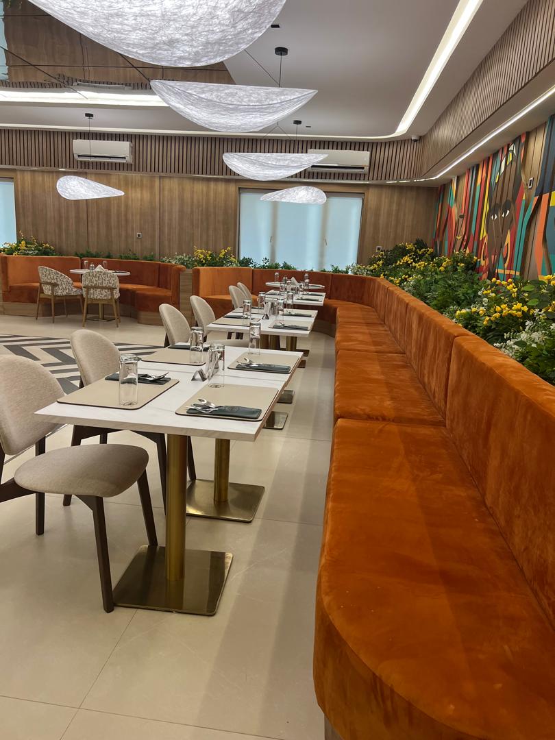 Curved blue seating beneath sculptural ceiling art in a hospitality setting